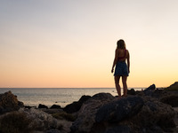 A woman enjoy the sunset at Cedar Forest (Kedrodasos) beach in Chania, Crete Island, Greece on August 18, 2022. (