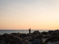 A man enjoy the sunset at Cedar Forest (Kedrodasos) beach in Chania, Crete Island, Greece on August 18, 2022. (