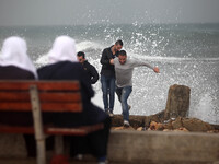 Palestinian youth are sprayed by seawater from rough seas at the Gaza seaport during a windy day in Gaza City on Oct. 25, 2015. (