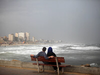  Palestinian  watches large waves from rough seas hit the break wall at the Gaza seaport during a windy day in Gaza City on Oct. 25, 2015....