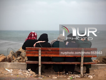  Palestinian  woman watches large waves from rough seas hit the break wall at the Gaza seaport during a windy day in Gaza City on Oct. 25, 2...