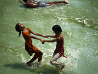 Children are enjoying the Hatirjheel Lake during the hot summer weather in Dhaka as hot and dry weather prevails in many parts of the countr...
