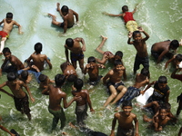 Children are enjoying the Hatirjheel Lake during the hot summer weather in Dhaka as hot and dry weather prevails in many parts of the countr...