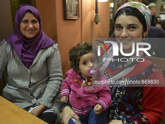 Halad from Syria with her daugther Elene  await for their evening meal at the Aspa Boomerang Restaurant, as the owner Michael Pastrikos, hel...