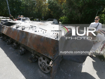 People look on destroyed Russian military vehicles captured in fights by Ukrainian army, displayed to the Independence Day, amid Russia's in...