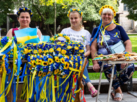 Women sell flower crowns  coloured with Ukrainian natinal colors in the old town of Lviv as they celebrate Ukrainian Independence Day, as we...