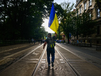 A man walks holding Ukrainian flag during a march on Independence Day of Ukraine in Krakow, Poland on  August 24, 2022. The day marks the 31...
