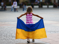 A girl runs around the Main Square holding Ukrainian flag on Independence Day of Ukraine in Krakow, Poland on  August 24, 2022. The day mark...