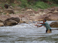 A fisherman casts his net in the Poonch river on Friday August 26, 2022 (