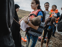 A young girl holds her brother after disembarking from a dingh from Turkey to Greece, in Lesbos, on September 26, 2015. More than 700,000 re...