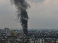 Smoke rises in the air from a community fire near a giant Buddha statue in Bangkok on August 30, 2022 in Bangkok, Thailand. (