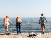 Men fish by the boulevard  in a famous Black Sea resort in  Odessa, Ukraine as the country surpasses 6 months after Russian invasion on Sept...
