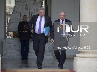 French Finance Minister Michel Sapin (R) and Budget Junior Minister Christian Eckert leave the Elysee palace on April 23, 2014, in Paris, af...