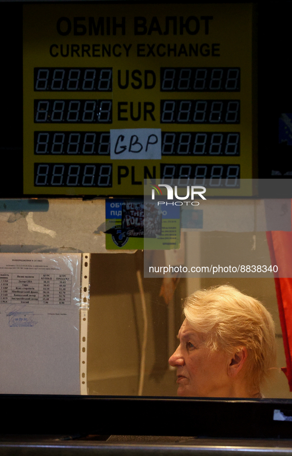 People walk past the empty exchange rates plates in Kyiv, Ukraine, August 5, 2022. The National Bank of Ukraine has banned non-banking insti...