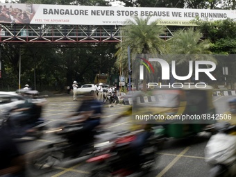 Movement of vehicles are seen with a background billboard written 'Bangalore Never Stops Because We Keep Running' in Bangalore, India, 13 Se...