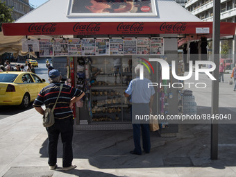 Two men are looking newspapers on a kiosk in the center of Athens, Greece on September 14, 2022. (