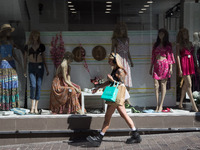 A woman is passing in front of a store at Ermou street in the center of Athens, Greece on September 14, 2022. (