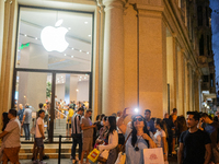 A woman is photographed in front of the Apple store on the day the new iPhone 14 went on sale, in Barcelona, ​​Spain, on September 16, 2022....