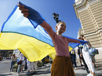 A girl holds national flag during a rally of Kherson residents timed to the Day of the city in the center of Odesa, Ukraine 17 September 202...