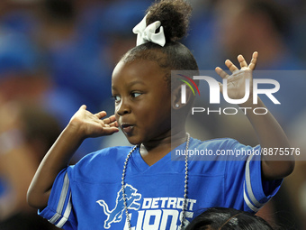 A young fan cheers in the stands during an NFL football game between the Detroit Lions and the Washington Commanders in Detroit, Michigan US...