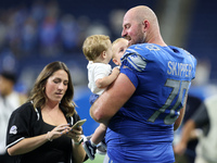 Detroit Lions offensive tackle Dan Skipper (70) holds his two children on the field after an NFL football game between the Washington Comman...