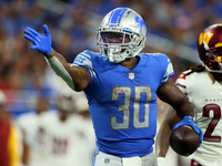 Running back Jamaal Williams (30) of the Detroit Lions signals after carrying the ball forward down the field during an NFL football game be...
