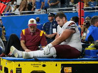Washington Commanders center Chase Roullier (73) is taken off the field after an injury during an NFL football game between the Washington C...