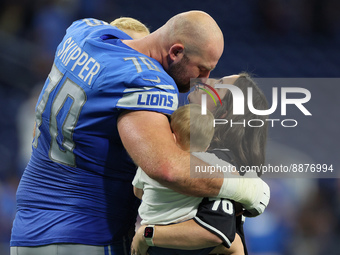 Offensive tackle Dan Skipper (70) of the Detroit Lions kisses his wife while they hold their children on the field after an NFL football gam...