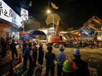Taiwanese officials and soldiers inspect  a deconstruction of a collapsed building after a 6.8 earthquake hitting Taiwan caused severe damag...