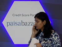 A woman talks on phone walks past a Paisa Bazar logo in Global Fintech Fest in Mumbai, India, 20 September, 2022.  (