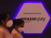 Women walk past a logo of Amazon Pay during Global Fintech Fest in Mumbai, India, 20 September, 2022. (