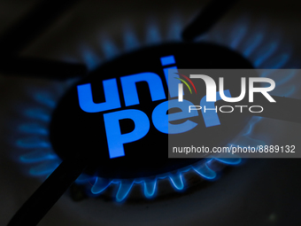 Uniper logo displayed on a phone screen and a gas burner are seen in this multiple exposure illustration photo taken in Krakow, Poland on Se...