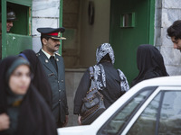 April 23, 2007 file photo shows, A morality policeman asks a woman to enter to a police station in Tehran. Thousands of Iranians protest the...
