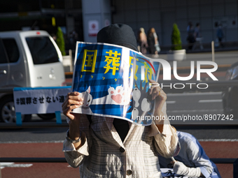 A protestor holds a placard against state funeral for Shinzo Abe during a demonstration in front of Shinjuku station in Tokyo, Japan, 25 Sep...