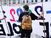 A vegan activist holds a banner during the climate march organized by Youth for Climate, in Paris, France, on September 25, 2022. (