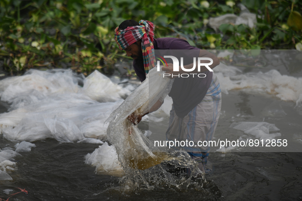 A worker cleans polyethylene as it use to carry chemicals at the river Buriganga in Dhaka, Bangladesh on September 26, 2022. Buriganga River...