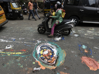 People pass by the potholes painted by a citizens' group in Mumbai, India, 26 September, 2022. Members of the Watchdog Foundation said they...