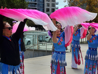 Chinese fan dancers dressed in traditional outfits practice before a performance during the Community Crime Awareness Day in Mississauga, On...