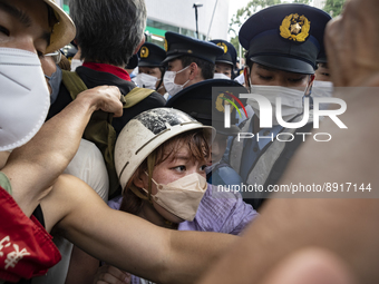 A female activist scuffles with police during a demonstration against the state funeral near the funeral’s venue in Tokyo, Japan, 27 Sep. (
