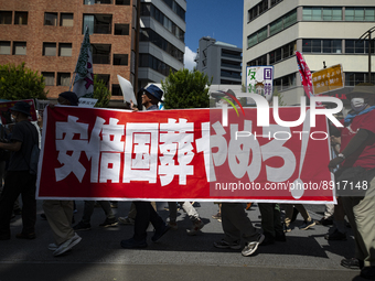 Protestors march with the placard against the state funeral for Shinzo Abe during the demonstration near the funeral’s venue in Tokyo, Japan...