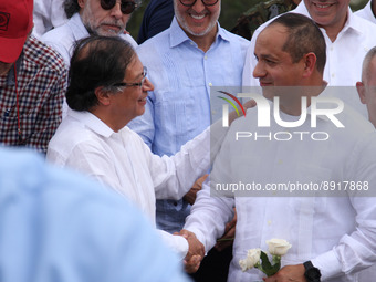 Colombian President Gustavo Petro (left) shakes hands with Venezuelan Transport Minister Ramon Velasquez (right) during the official reopeni...