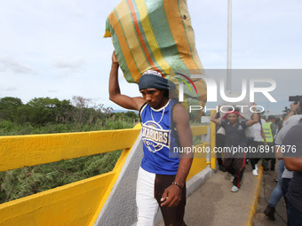 A person carrying packages is seen crossing through the Simon Bolivar International Bridge, during the official reopening ceremony of the bo...