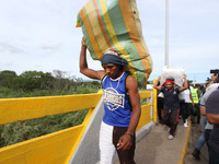 A person carrying packages is seen crossing through the Simon Bolivar International Bridge, during the official reopening ceremony of the bo...