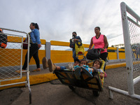People carrying packages are seen crossing through the Simon Bolivar International Bridge, during the official reopening ceremony of the bor...