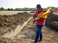 A farmer unionist walks near an excavation in an agricultural field. The collectives 'La Voie Est Libre' (ie 'The Way Is Free') and the farm...