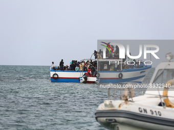 A small sailboat crowded with nearly 118 people and a unity of Tunisian guards coast watch them (