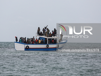 Migrants on small sailboat waiting to transfer  (