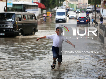 Palestinian school children walk in a street flooded by rain water in Gaza city, November 9, 2015. Heavy rains continue to lash several part...
