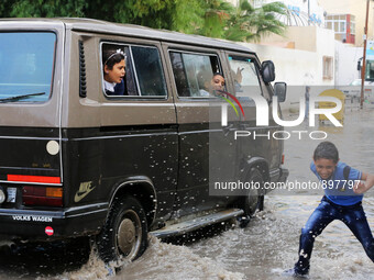 Palestinian school children walk in a street flooded by rain water in Gaza city, November 9, 2015. Heavy rains continue to lash several part...