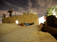 KIFL HARETH, WEST BANK - APRIL 24: An Israeli soldier stands guard as an Ultra-Orthodox Jews lays on the tomb of Nun, father of Biblical Isr...
